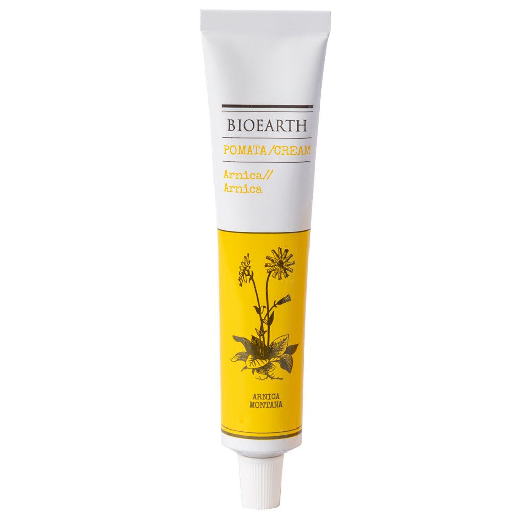 A white and yellow tube labeled Bioearth Pomata/Cream Arnica, featuring an illustration of an arnica plant on the front, highlights its soothing botanical properties. Tube is cylindrical with a matte finish; label has black and green sans-serif text. The product stands upright on a plain white background. No people or hands are present in the image.