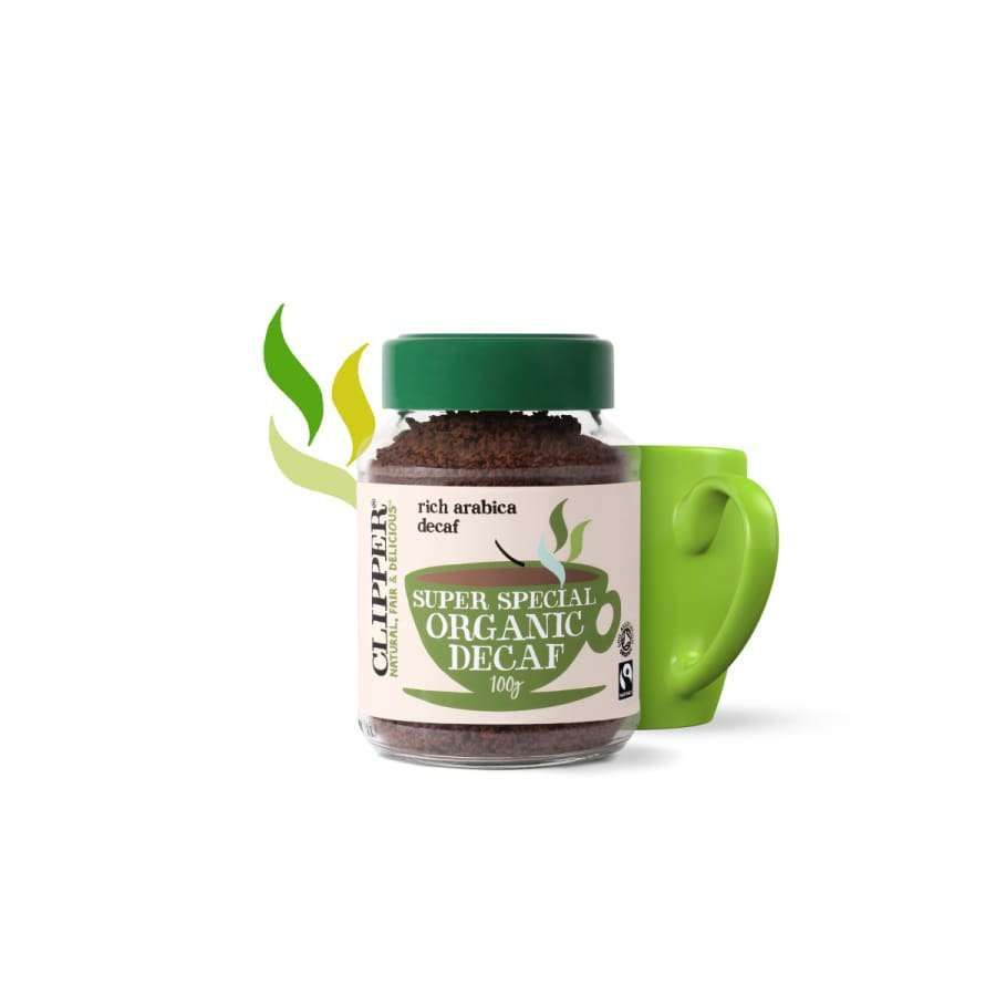 Clipper Super Special Organic Decaf -pikakahvi; purkki vihreän mukin edessä, vieressä lehtiaiheinen luomukuvitus valkoisella taustalla; kirkas lasipurkki kultaisella metallikannella, suorakulmainen muoto, näkyvissä ruskeita rakeita; etiketissä mustaa ja valkoista groteskitekstiä vihrein koristein; ei ihmisiä; hyvin valaistu ja keskitetty kuva.