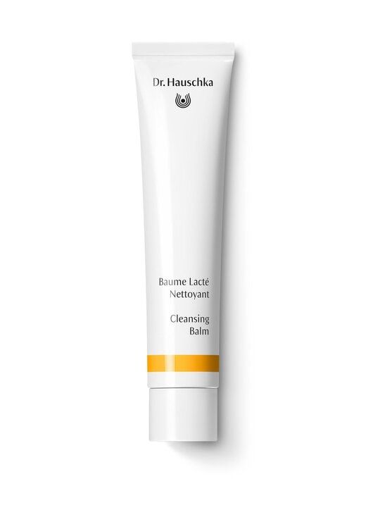 A white tube of Dr. Hauschka Cleansing Balm featuring black text and a calendula-inspired yellow stripe near the bottom, displayed on a white background. The tube has a matte finish and tapers slightly toward the cap. Typography is sans-serif and minimal. The only visible words are product and brand name, without additional graphics or patterns. No hands or props are present in the image.