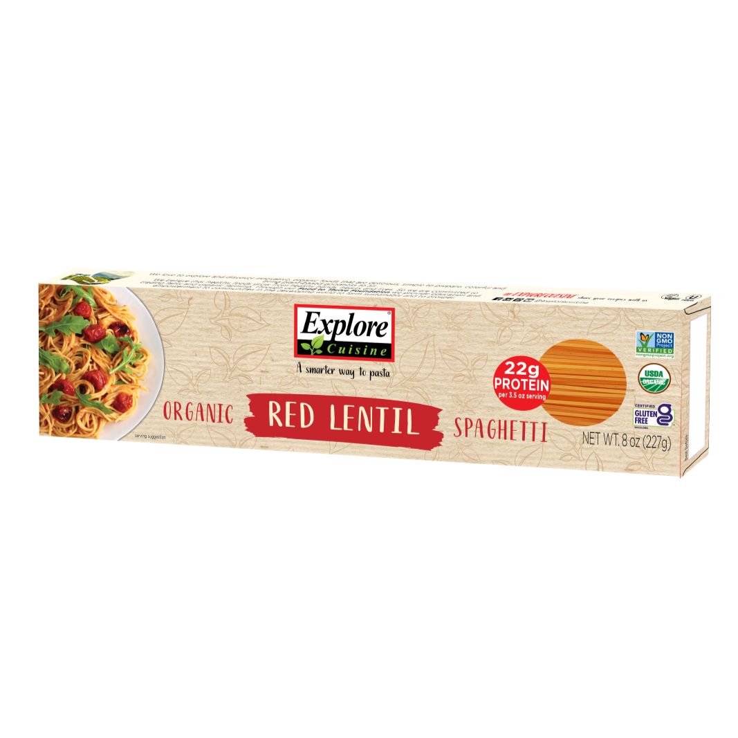 Explore Cuisine Luomu Punainen Linssi Spagetti -pakkaus, 8 oz, kuva lautasellisesta pastasta; pakkaus suorakulmainen ja kiiltäväpintainen, punaisin, vihrein, valkoisin ja mustin värilohkoin; suuri lihavoitu brändinimi yläosassa; luettavassa tekstissä 22 g proteiinia annosta kohden, USDA Organic- ja gluteeniton-sertifioinnit; ei ihmisiä tai käsiä näkyvissä; valkoinen studiotausta, suora tuotekuva.