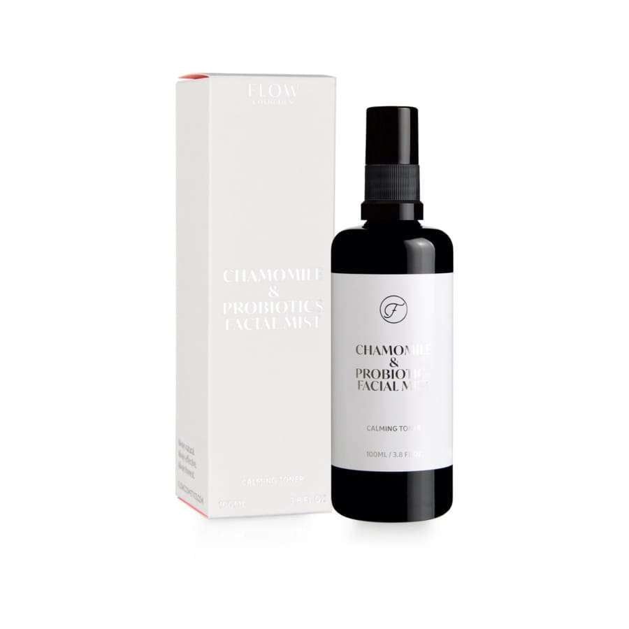 Flow Cosmetics Chamomile & Probiotics Facial Mist; musta, pystyssä seisova suihkepullo valkoisen, suorakulmaisen rasian vieressä, samalla tekstillä minimalistisella groteskityypillä; molemmissa mattapinta; ei ihmisiä tai käsiä kuvassa; hyvin valaistu, suoraan edestä kuvattu.