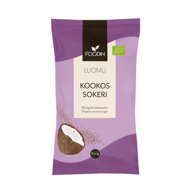 Foodin Luomu Kookossokeri -pussi, violetti, 600 g, kookoskuvitus sekä teksti suomeksi ja englanniksi; joustava mattapintainen pakkaus pystyssä suorakulmaisessa muodossa; valkoista tekstausvapaata typografiaa brändille ja tuotetiedoille; tuote kuvattu valkoista taustaa vasten, ei ihmisiä tai rekvisiittaa näkyvissä.