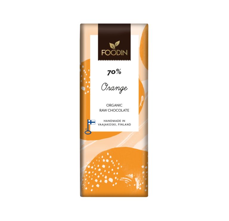 Foodin Luomu Raakasuklaa Orange 70 % -suklaapatukka; suorakulmainen, mattapintainen käärepaperi geometrisella oranssilla ja valkoisella kuviolla; teksti kertoo tuotteen käsintehdyksi Vaajakoskella laadukkaista ainesosista; tekstausvapaalla kirjasimella painettu "70%" ja "Orange"; kuvattu suoraan edestä yksiväristä taustaa vasten, ei ihmisiä tai käsiä näkyvissä.