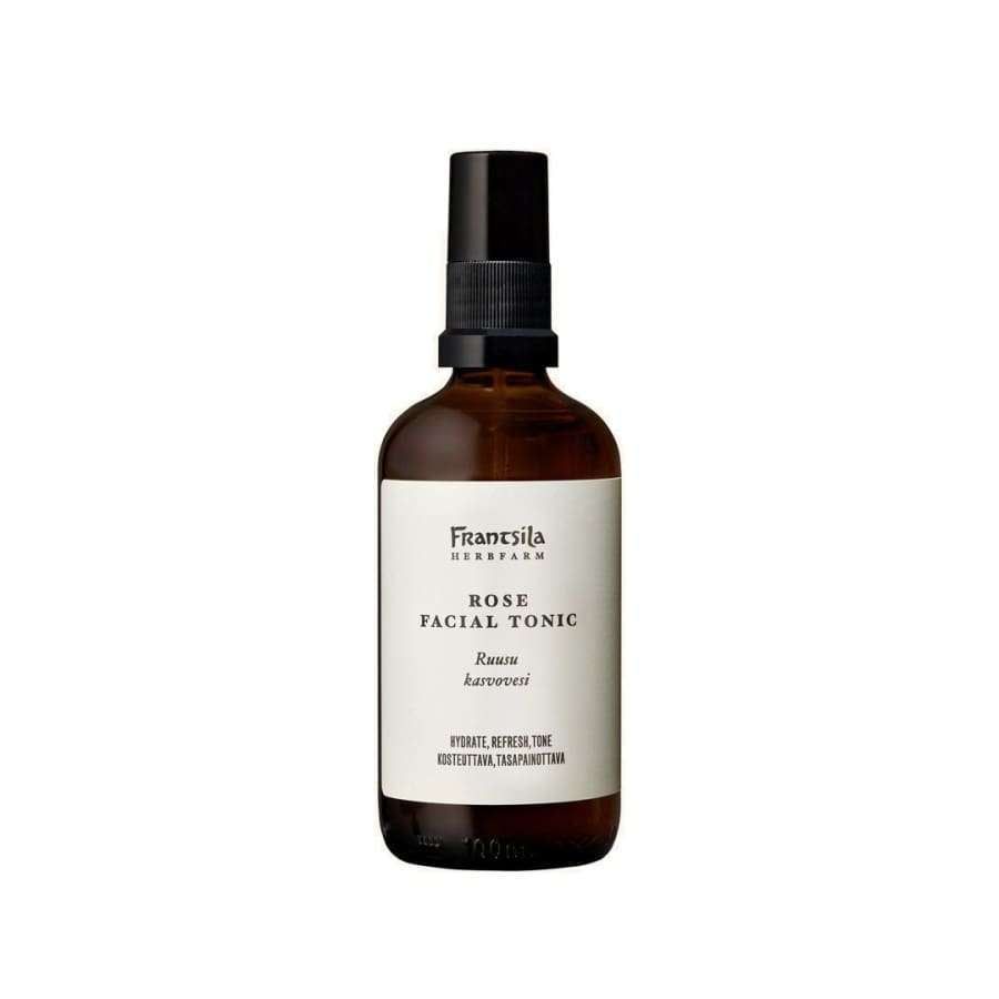 Frantsila Ruusu Kasvovesi; ruskea suihkepullo tekstillä "Frantsila Rose Facial Tonic", musta muovinen korkki, lieriömäinen muoto ja sileä mattapinta; pullo seisoo pystyssä yhtenäisen valkoisen taustan edessä; etuetiketissä tuotetiedot sekä englanniksi että suomeksi, sekoitettuna serif- ja groteskifontein; ei ihmisiä tai käsiä kuvassa.