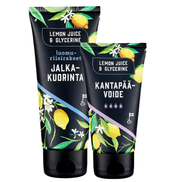 Lemon Juice & Glycerine Jalkahoito 2-pack; kaksi mustaa tuubia eloisin sitruuna- ja lehtikuvioin, merkitty Jalka-kuorinta ja Kantapää-voide; pakkaus muovia mattapinnalla ja selkeää modernia suomenkielistä typografiaa; ainesosina mainitaan Lemon Juice & Glycerine; tuubeissa läppäkannet, seisovat neutraalilla alustalla ilman ihmisiä tai käsiä.