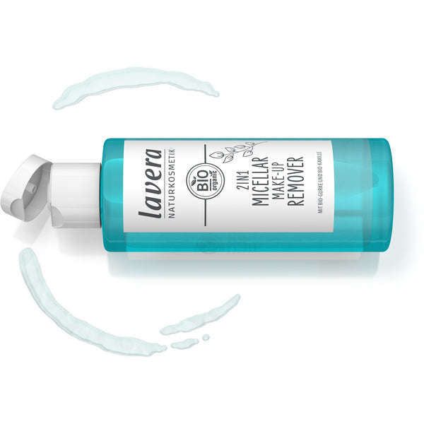 Lavera 2in1 Micellar Meikinpoistoaine; sininen muovipullo tekstillä "Lavera 2in1 Micellar Make-Up Remover" kyljellään valkoisella läppäkorkilla; etiketissä lihavoitua ja tavallista groteskitekstiä mustana ja vaaleansinisenä; läpinäkyvää micellaarista nestettä valuu pullon ympärille; pullon pinta kiiltäväpintainen; yhtenäinen valkoinen tausta, ei ihmisiä tai käsiä kuvassa, studiotuotekuva suoraan edestä.