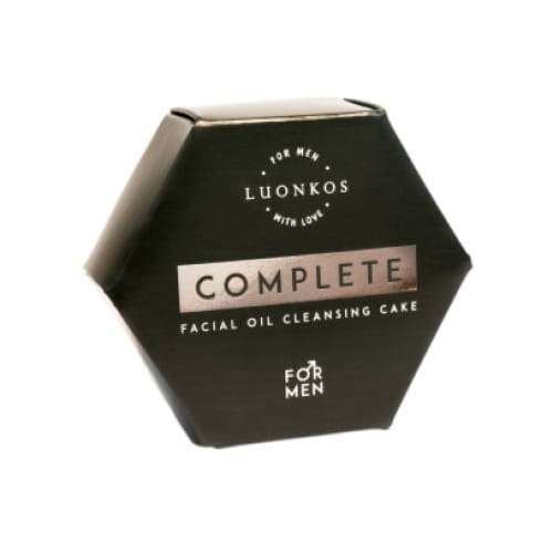 Luonkos Complete Facial Oil Cleansing Cake For Men; kuusikulmainen musta rasia hopeanvärisin korostuksin ja minimalistisella designilla valkoista taustaa vasten; rasia mattamusta, hopeanvärinen yksityiskohta etupinnalla, suorat reunat ja terävät kulmat; yksinkertaista groteskitekstiä; ei ihmisiä tai käsiä; tuote keskitetty kuvassa, kuvattu suoraan edestä.