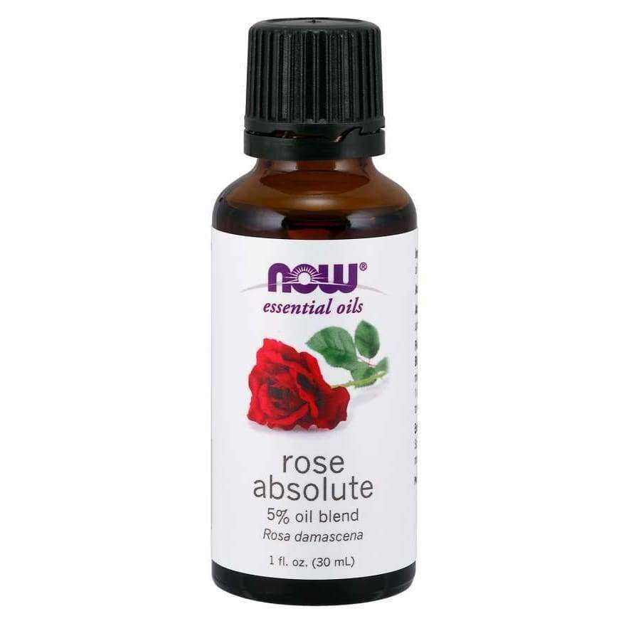 NOW Essential Oils Rose Absolute 5% Oil Blend, 1 fl. oz. (30 mL); ruskea, lieriömäinen, kiiltäväpintainen lasipullo, musta muovikorkki; valkoisessa etiketissä kuva punaisesta ruususta vihrein lehdin sekä violettia ja mustaa groteskitekstiä; vaalea tausta, tuote keskitetty pystyasennossa kuvassa, ei ihmisiä.