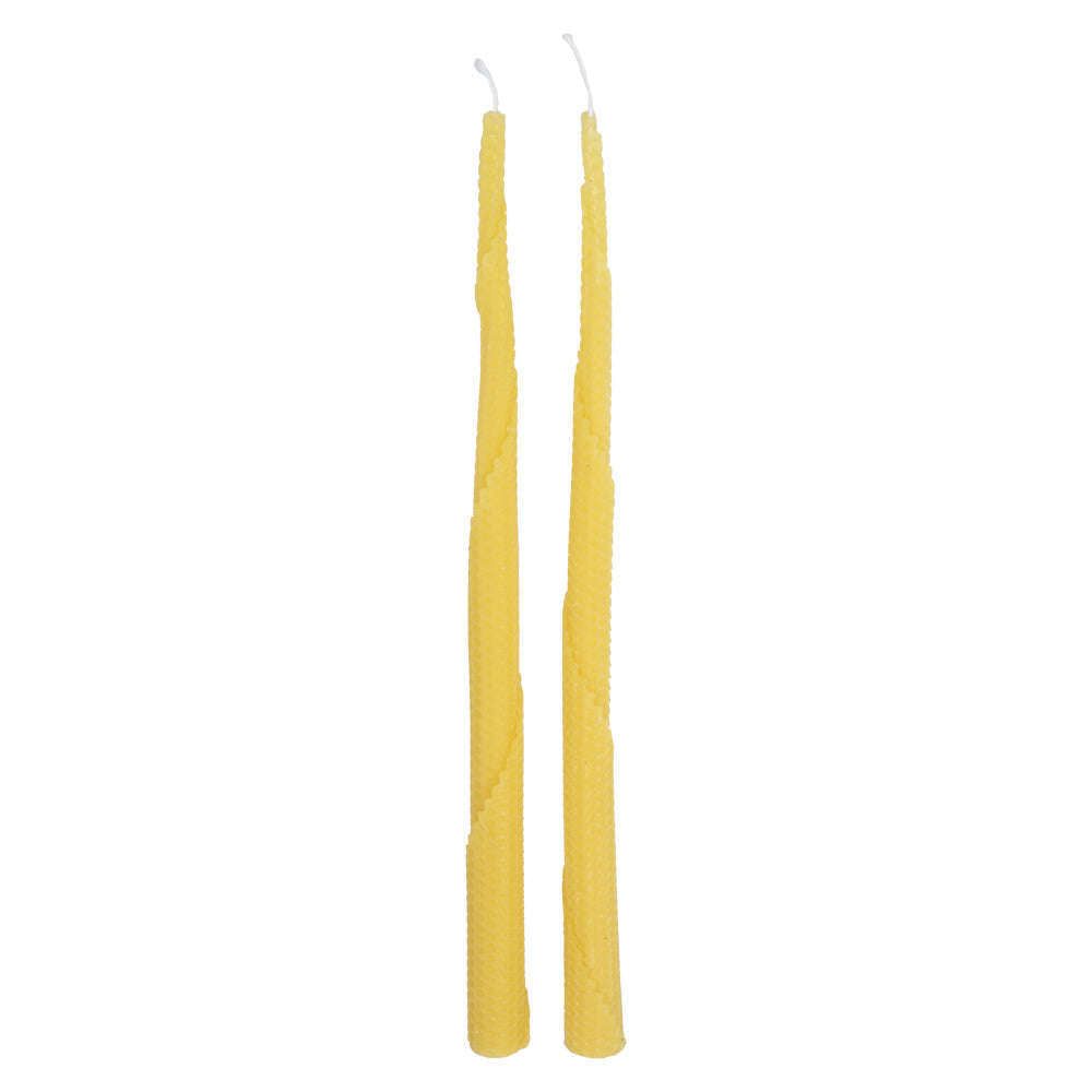 Two tall, yellow, spiral-patterned beeswax taper candles with visible wicks stand side by side against a white background. Cylindrical shape tapers toward unlit tips; both candles have a matte finish and no packaging or labels shown. No people, hands, or additional objects in frame; minimal studio-style product photo with even lighting.