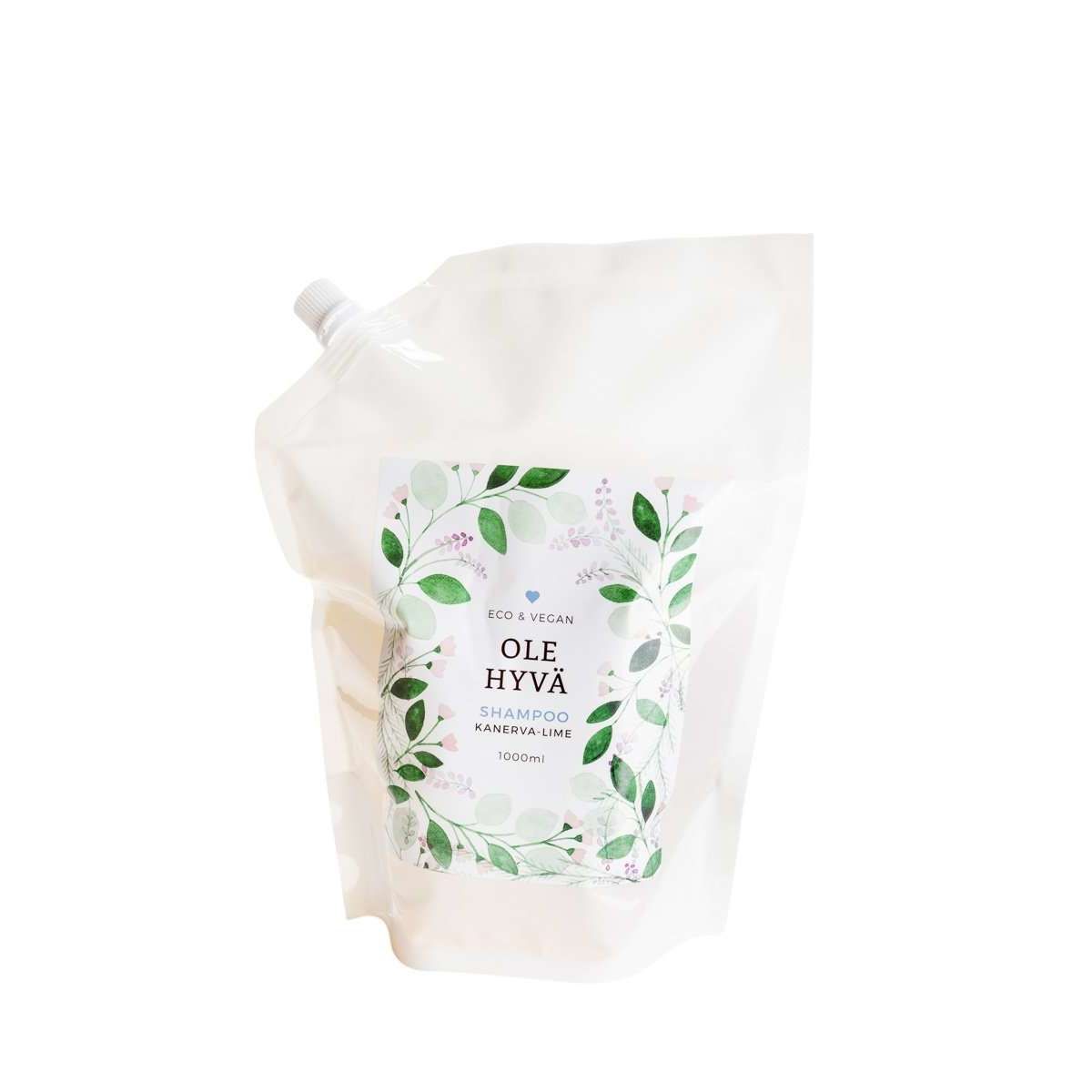 Ole Hyvä Shampoo Kanerva-Lime -täyttöpussi, 1000 ml; valkoinen, mattapintainen pussi nokkakorkilla; etiketissä yksinkertaista mustaa ja vihreää tekstausvapaata tekstiä sekä vihreiden lehtien kuvitus; näkyvissä teksti "Shampoo", "kanerva-lime" ja "1000 ml"; kuvattu pystyssä silmän korkeudelta neutraalia taustaa vasten, ei ihmisiä tai käsiä näkyvissä.