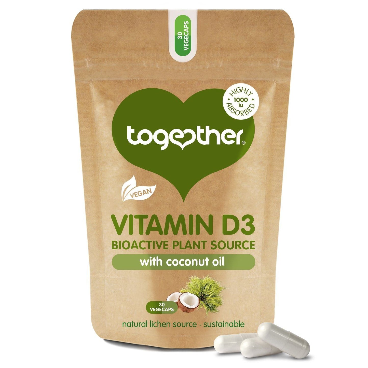Brown resealable pouch labeled Together Vitamin D3 with coconut oil, featuring vegan and plant source icons. Matte finish, flexible packaging stands upright. Legible text in sans-serif font; illustrations of hazelnuts and green leaves are present on the front. Three white capsules placed directly in front of the pouch on a plain background. No people or hands are visible.