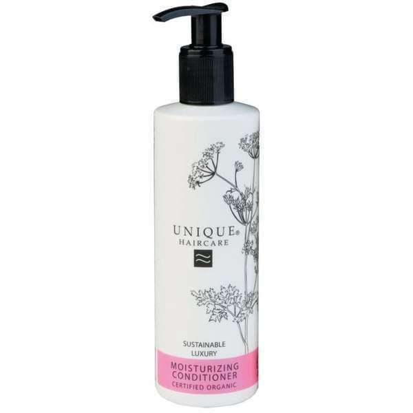 Unique Haircare Kosteuttava Hoitoaine; valkoinen pullo, musta muovipumppu; lieriömäinen, mattapintainen, keskiosassa kukkakuvio; alaosassa suorakulmainen vaaleanpunainen etiketti, jossa tiivistä mustaa ja valkoista groteskitekstiä sekä tuotenimi; vaalea tausta, ei ihmisiä.