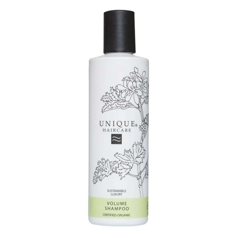 Unique Haircare Tuuheuttava Shampoo -pullo, musta korkki, kasvipiirroksia, vihreä sertifioitu luomu- ja vegaaniteksti; sylinterinmuotoinen mattapintainen muovipullo litteällä yläosalla, musta-valkoinen groteskiteksti