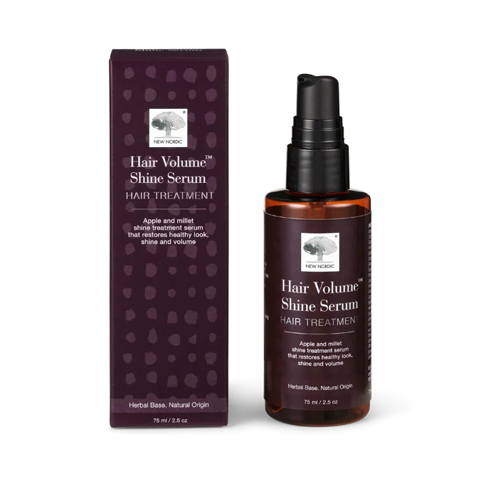 Hair Volume Hair Serum; lieriön muotoinen, läpinäkyvä ja pumppuannostelijalla varustettu pullo New Nordic -brändiltä sekä sitä vastaava violetti, kiiltäväpintainen suorakulmainen pakkaus; molemmissa lihavoitu, moderni valkoinen groteskiteksti mainitsee omena- ja hirssiainesosat; neutraali tausta.