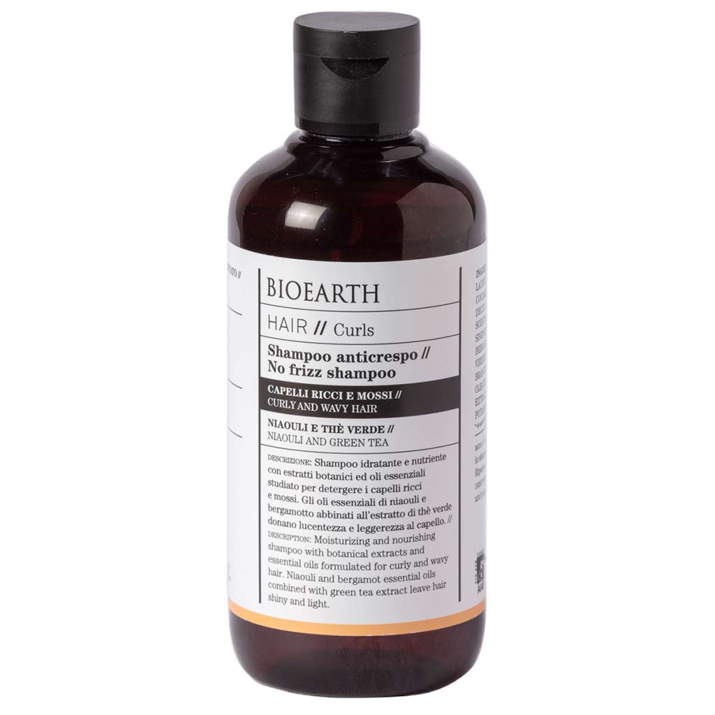 Bioearth HAIR 2.0 Shampoo kiharille hiuksille; ruskea, mattapintainen ja lieriön muotoinen pullo mustalla kierrekorkilla; minimalistinen typografia "No Frizz Shampoo" kihara- ja aaltohiuksille; valkoinen tausta, tuote keskellä.