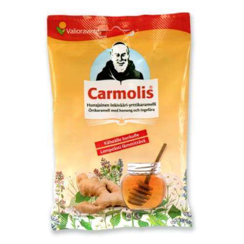 Carmolis Hunajainen Inkivääri Yrttikaramelli; keltaoranssi joustopussi mattapinnalla, suorakulmainen; etusivulla painettuja kuvia kaapuun pukeutuneesta munkista, viipaloidusta inkiväärijuuresta sekä lasisesta hunajapurkista puulusikan kera; suomen- ja ruotsinkielistä tekstiä groteskifontilla; ei ihmisiä tai käsiä; tuote pystyssä vaalealla taustalla.