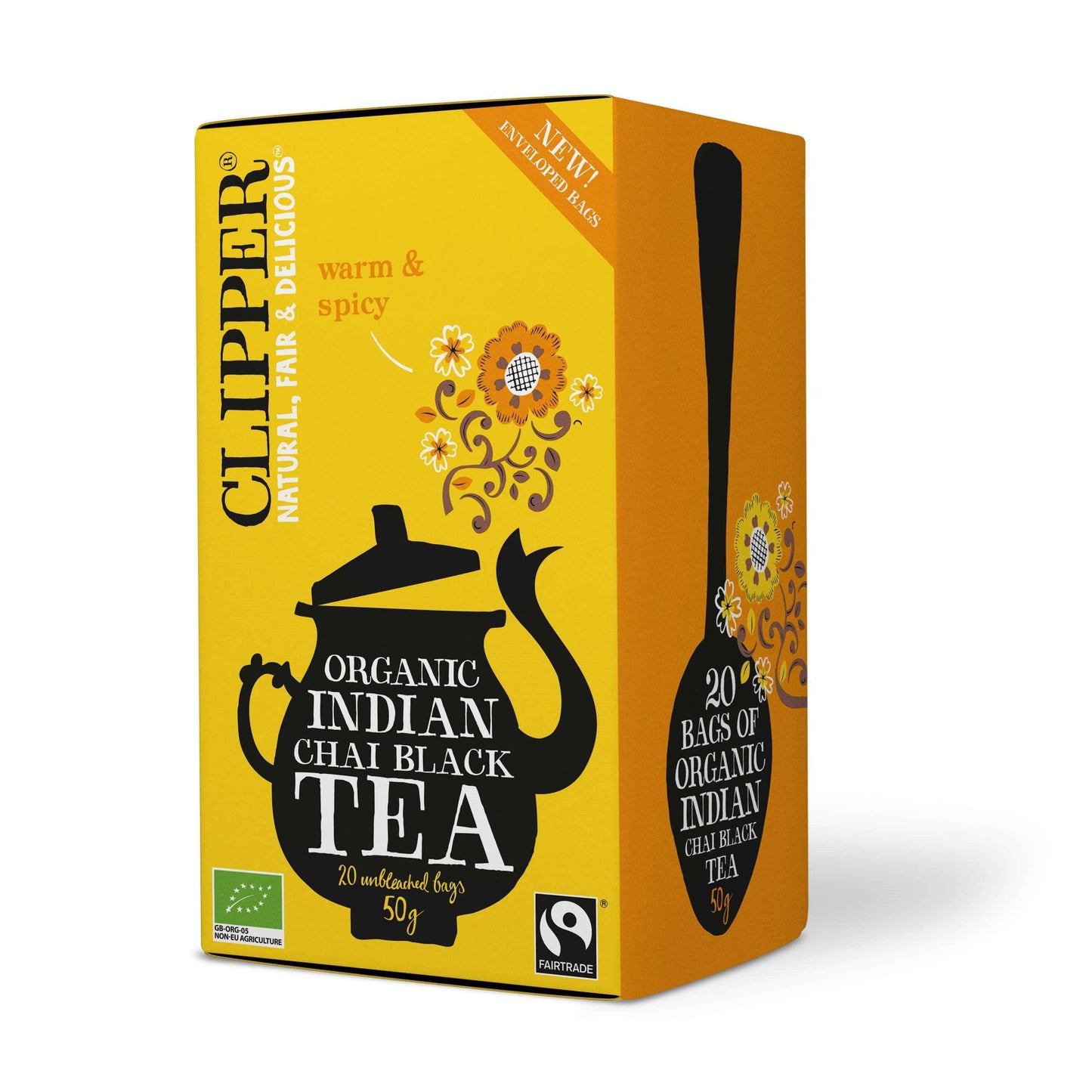 Clipper Organic Indian Chai Black Tea; keltainen ja oranssi rasia, jossa musta teekannun kuvitus ja kukkakuvioita; suorakulmainen pakkaus mattapinnalla, valkoista ja mustaa groteskitekstiä; etiketissä maininta 20 biohajoavasta pussista sekä "warm & spicy" -maku; ei ihmisiä tai käsiä; vaalea, siisti tausta.