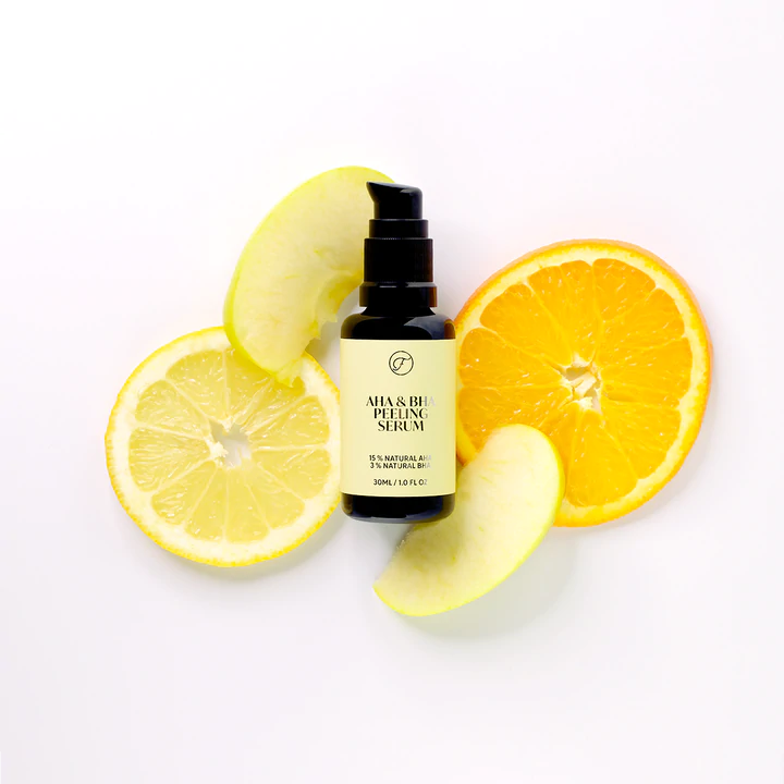 FLOW Cosmetics AHA & BHA Peeling Yöseerumi; ihonhoitoseerumipullo keskellä, ympärillä sitruuna-, appelsiini- ja tuoreen omenan viipaleita valkoisella taustalla; pullo sylinterinmuotoinen kirkkaasta tai huurrelasista mattaisella tai kiiltäväpintaisella pinnalla, päällä pipettikorkki; etiketissä yksinkertainen groteskityyppografia; kaikki hedelmät aseteltu tasaisesti pullon ympärille; ei ihmisiä kuvassa, ylhäältä kuvattu.