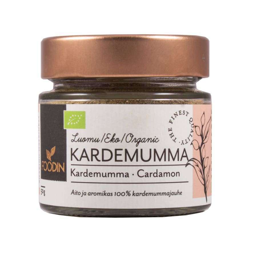 Foodin Luomu Kardemummajauhe; pieni lasipurkki, ruskea mattapintainen muovinen kierrekansi; lieriömäinen, läpinäkyvä lasi, jossa näkyy vaaleanruskeaa jauhetta; etiketti pääosin tummanvihreä, valkoista ja vaaleankultaista groteskitekstiä, kasvikuvitus, pieniä pyöreitä logoja sekä suomen- ja englanninkielistä tekstiä; tuote kuvattu vaalealla taustalla edestäpäin.