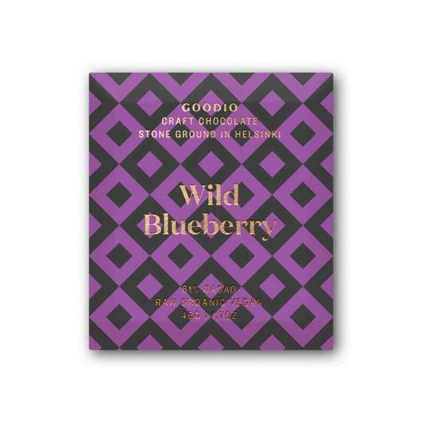Goodio Luomu Wild Blueberry Raakasuklaa 61 % -suklaapatukka; violetin ja mustan geometrisella kuviolla varustettu, mattapintainen käärepaperi; lihavoitua suuraakkosista valkoista tekstausvapaata tekstiä "GOODIO Craft Chocolate Stone Ground in Helsinki Wild Blueberry 61% Cacao Raw Organic 1.7oz"; kuvattu tasokuvana yksiväristä taustaa vasten, ei ihmisiä tai käsiä näkyvissä.