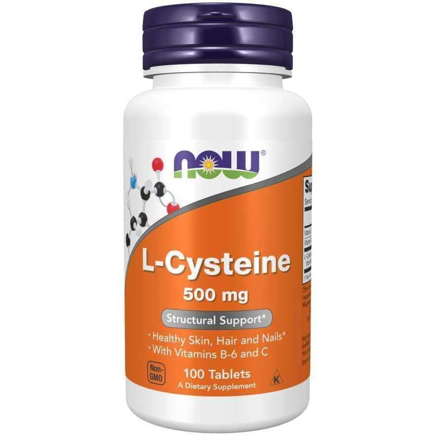 Now Foods L-Kysteiini 500 mg; valkoinen pullo tekstillä "NOW L-Cysteine 500 mg" -ravintolisää, kiiltävä pinta, lieriömäinen muoto ja yhtenäinen violetti kierrekorkki; oranssissa etiketissä lihavoitua typografiaa valkoisena ja violettina, näyttää tuotenimen, annostuksen, vitamiini- ja antioksidanttihyödyt iholle, hiuksille ja kynsille sekä maininnan "100 tablets"; tausta vaalea ilman rekvisiittaa tai ihmisiä.