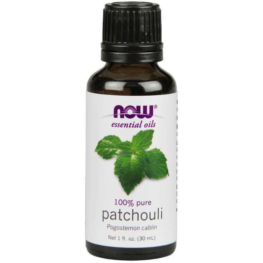 NOW Essential Oils 100% Pure Patchouli, 1 fl. oz.; tummanmeripihkanvärinen lasipullo, musta uritettu muovikorkki; valkoisessa etiketissä kuva vihreistä patsulinlehdistä, keskitetty lehtikuvitus sekä mustaa ja violettia sans serif -tekstiä; mattapinta; vaalea tausta, ei ihmisiä; tuote kuvattu suoraan edestä.