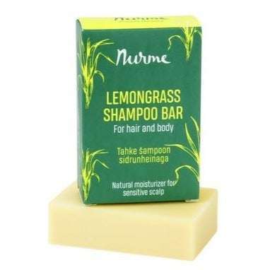 Lemongrass Shampoo Bar -laatikko sitruunaruohonvihreänä, sijoitettuna vaaleankeltaisen suorakulmaisen shampoopalan päälle; laatikko mattapinnalla, suorakulmainen muoto ja painetuin sitruunaruohokuvituksin; etiketissä lihavoitua serif- ja tekstausvapaata fonttia valkoisella ja keltaisella; teksti kertoo käytöstä hiuksille, vartalolle ja herkälle päänahalle; tausta yksinkertainen, kuva lähikuva ilman ihmisiä.