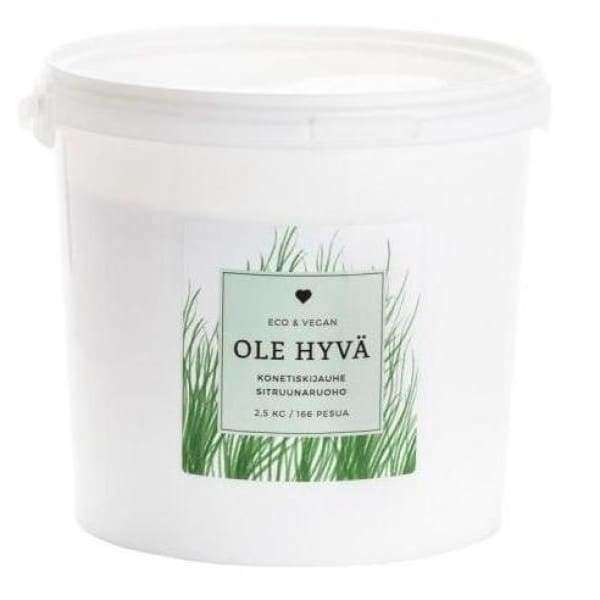 Ole Hyvä Konetiskijauhe Sitruunaruoho -purkki vihrein ruohokuvituksin, etiketissä OLE HYVÄ ja ECO & VEGAN; etiketissä myös maininta sopivuudesta 186 pesukertaan ja sisällöksi 2,5 kg, tehden siitä vegaaniystävällisen valinnan ympäristötietoiselle kuluttajalle; purkki sylinterimäinen valkoisella kannella, mattapinta ja yksinkertaista tekstausvapaata fonttia etiketissä; tausta valkoinen; ei ihmisiä tai käsiä näkyvissä; kuva selkeästi keskitetty tuotteen etuosaan.