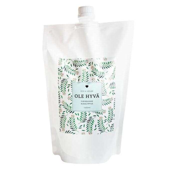 Ole Hyvä Yleispesusuihke Eukalyptus -täyttöpussi; vihreä lehtikuvio ja etiketti, jossa lukee OLE HYVÄ, Eco & Vegan, Yleispesuaine, Eucalyptus; pussi mattapintainen ja joustavaa muovia, kaartuva yläosa ja näkyvät saumat; typografia yksinkertaista ja tekstausvapaata; ei ihmisiä tai käsiä näkyvissä; tausta vaalea studiotyyli, tuote keskitettynä kuvaan.