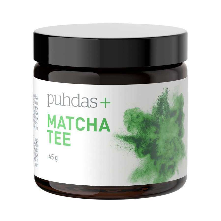 puhdas+ Matcha Tee, 45 g; tumma, lieriömäinen purkki mustalla kiiltävällä kierrekannella; etiketissä selkeää groteskitekstiä sekä kuva kirkkaanvihreästä matchajauheesta; purkin pinta heijastava; vaalea tausta tasaisella valaistuksella ilman varjoja; ei ihmisiä tai käsiä; tuote keskitetty ja tarkkarajainen.