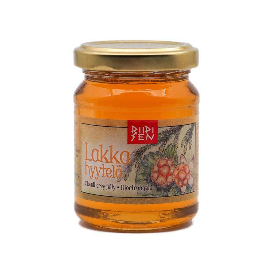 Riipisen Lakkahyytelö; lasipurkki tekstillä "Lakka hillo", kultainen metallinen kierrekansi, lieriömäinen muoto ja sileä kiiltäväpinta; etuetiketti valkoinen värillisin lakkakuvituksin, tekstiä ainakin kahdella kielellä selkeällä groteskifontilla; neutraali tausta, ei ihmisiä tai käsiä; suoraviivainen tuotekuva.
