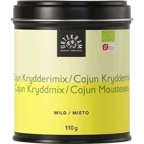 Urtekram Luomu Cajun-mix -purkki, 110 g, kirkkaankeltainen mattaetiketti; sylinterinmuotoinen metallipurkki, tasainen kansi, musta-valkoinen teksti useilla kielillä, "Mild" ja "organic" mainittu