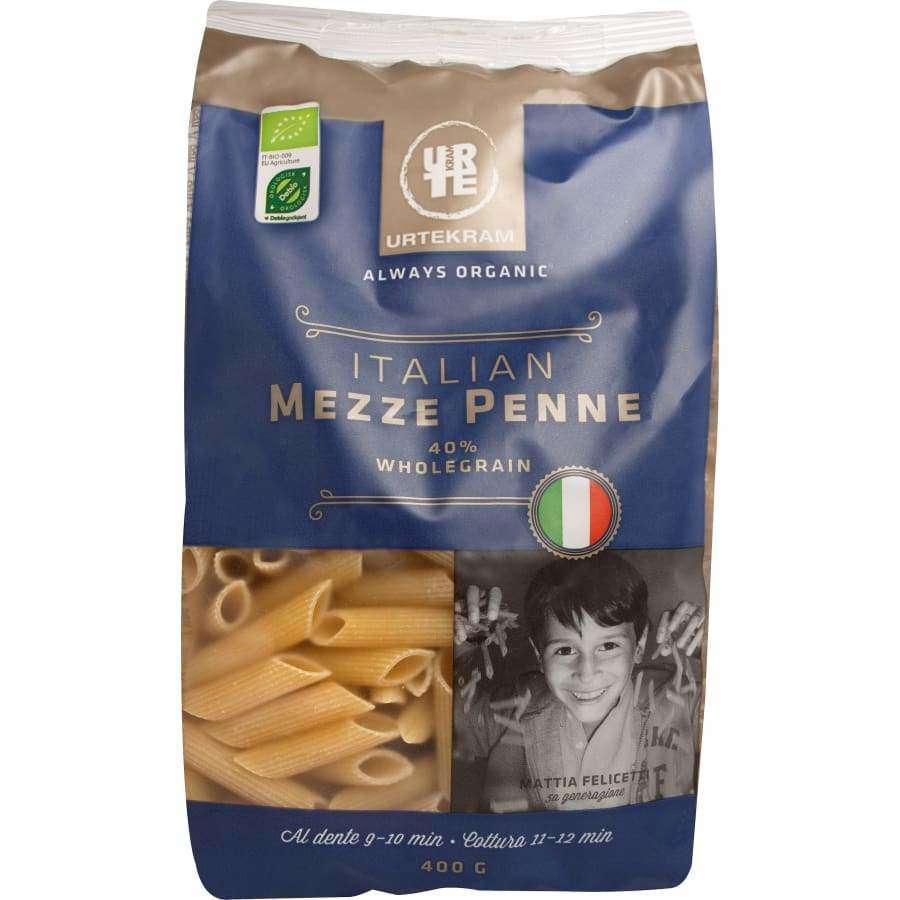 Urtekram Luomu Mezze Penne -täysjyväpasta, 400 g; pakkauksessa Italian lippu, luomumerkinnät, kuva hymyilevästä pojasta sekä penne-pastasta; keittoajaksi ilmoitettu 9–12 minuuttia; suorakaiteen muotoinen, mattapintainen paperipakkaus monivärisellä painatuksella; tuotenimi lihavoidulla tekstausvapaalla kirjasimella; ei käsiä näkyvissä.