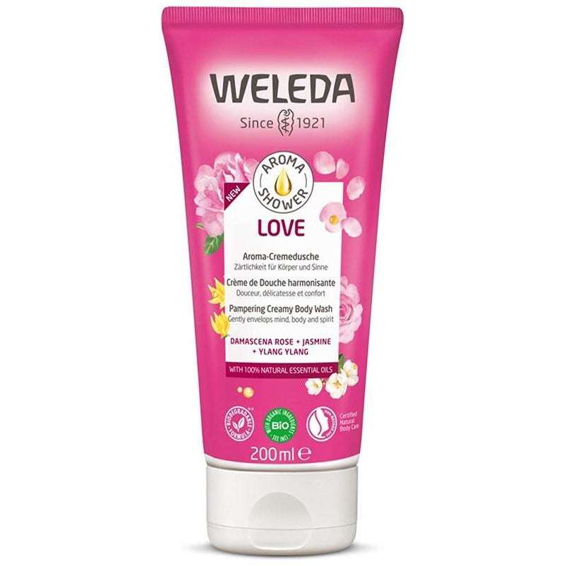 Weleda Love Suihkuvoide, 200 ml; vaaleanpunainen mattapintainen puristeltava tuubi pystyssä; etiketissä yksinkertaisia kukkakuvioita ja teksti sisältää damaskusruusun, jasmiinin ja ylang ylangin öljyt ainesosina; tilavuus näkyvissä selkeästi; ei ihmisiä tai muuta ympäristöä, tuote yksin kuvattuna.