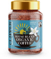 Clipper House Blend Organic Coffee; sininen etiketti, jossa auringon- ja kahvikuppikuvituksia, Fairtrade- ja luomulogot sekä teksti "sunshine in a cup"; lasipurkki lieriömäinen, musta kierrekansi, mattapintainen; etiketissä valkoista ja keltaista groteskitekstiä; tuote pystyssä vaalealla taustalla, ei ihmisiä.