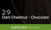 Biokap Nutricolor Delicato Kestoväri; lähikuva tummanruskeasta tukasta tekstillä 2.9 Dark Chestnut - Chocolate ja vihreä nauha alaosassa tekstillä nutricolor delicato, korostaen rikasta kastanjansävyä; tukka sileä ja kiiltävä täyttäen suurimman osan kuvasta; teksti selkeällä groteskikirjasimella valkoisena ja kultaisena, vihreässä nauhassa valkoinen pienaakkosteksti; ei käsiä tai ihmisiä, tausta neutraali, keskittyy tukkaan ja etikettiin.