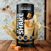 3K Protein Shake Salted Caramel; Layenberger 3K Protein Shake -tölkki suolakaramellin makuisena pystyssä; tölkki sylinterin muotoinen metallisella kiiltopinnalla; etiketissä moderni lihavoitu teksti ”Layenberger 3K Protein Shake” ja ”Salted Caramel”; ympärillä vaaleanbeigejä shakeroiskeita ja neliönmuotoisia karamellikuutioita; taustalla rustiikkia puulautoja; ei ihmisiä tai käsiä kuvassa.