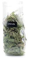 Aduki Luomu Stevian lehti; kirkas muovipussi täynnä kuivattuja steviankukkalehtiä, etiketissä lukee Stevia Leaf mustassa tarrassa; pussi suorakulmainen rypistyneellä pinnalla ja kuumasaumatulla yläreunalla; sisältö vaaleanvihreää ja näkyy läpinäkyvän pakkauksen läpi; musta matta etiketti lihavoidulla valkoisella groteskikirjasimella; kuva otettu valkoista taustaa vasten ilman ihmisiä tai esineitä.