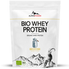 AlpenPower Luomu Heraproteiini Natural; valkoinen AlpenPower Bio Whey Protein -pussi kuvituksena vuohi, maitokannu ja vuoret; matta muovinen pakkaus vetoketjullisella suulla, suorakulmainen muoto; yksinkertainen groteskikirjasin mustana ja vihreänä; luettavissa tuotenimi, maininta luomuainesosista, neutraalin maun huomautus ja 500 gramman paino; tausta tasainen ilman näkyvää ympäristöä tai ihmisiä; suoraan edestä otettu tuotekuva.