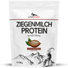 AlpenPower Vuohenmaitoproteiini Suklaa; valkoinen AlpenPower-proteiinipöly-pussi tekstillä ”Ziegenmilch Protein”, kuvituksena kaakaopalko, vuori ja vuohi; matta pussi lihavoidulla mustalla ja ruskealla tekstillä; tausta neutraali, ei ihmisiä, tuote silmän korkeudella.