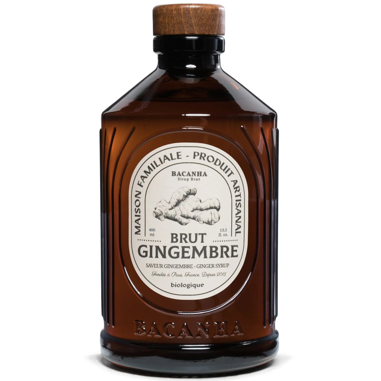 Bacanha Luomu Inkiväärisiirappi; ruskea lasipullo Bacanha Brut Gingembre -luomuinkiväärisiirappi, puukorkki ja suuri vintage-tyylinen ranskankielinen etiketti korostaen käsityöläisyyttä; suorakaiteen muotoinen pullo pyöristetyin reunoin, kiiltäväpintainen; musta serif-teksti luonnonvalkoisella pohjalla; neutraali studiotausta ilman ihmisiä.