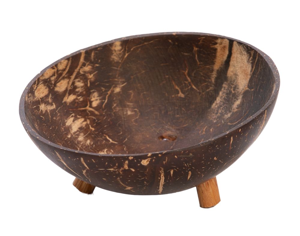 A bowl crafted from a coconut shell with a natural, textured surface, round in shape, and supported by three short cylindrical wooden legs. The finish is matte with visible grain patterns unique to coconut shells. There is no packaging or label text present. The item is photographed against a white background. A bowl crafted from a coconut shell with a natural, textured surface, sitting on three short wooden legs against a white background—an eco-friendly addition to your décor.