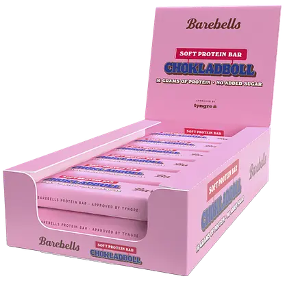 Barebells Soft Chokladboll Proteiinipatukka; vaaleanpunainen suorakulmainen pahvilaatikko Barebells Soft Protein Bars -tuotetta Chokladboll-maussa, mattapinnalla, sisällä useita yksittäin käärittyjä patukoita näkyvissä; etupuolen typografia on lihava ja moderni, ”16 grams of protein” ja ”no added sugar” selkeästi esillä; pakkaus kuvattu vaaleaa taustaa vasten; ei ihmisiä tai käsiä näkyvissä.