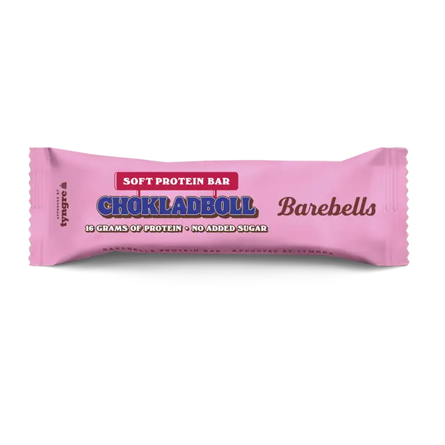 Barebells Soft Chokladboll Proteiinipatukka; vaaleanpunainen Barebells-kääre pehmeälle proteiinipatukalle, merkitty Chokladboll, sisältää 16 grammaa proteiinia ja ilman lisättyä sokeria; pakkaus on mattapintainen lihavin mustin ja valkoisin groteskitekstein etupuolella; kääre on suorakulmainen sahalaitaisin reunoin; ei ihmisiä tai käsiä näkyvissä; tausta neutraali, lähikuva pakatusta patukasta; herkullinen vaihtoehto nopeaan, proteiinipitoiseen välipalaan.
