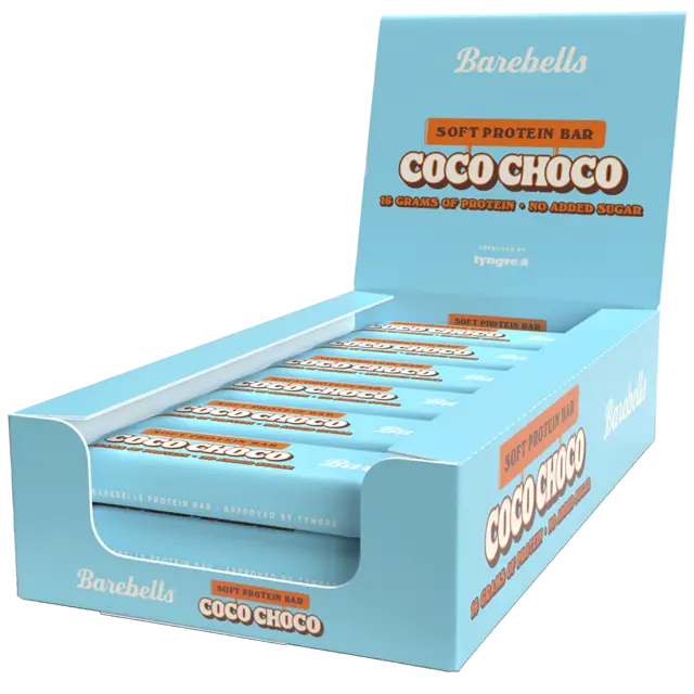Barebells Soft Coco Choco Proteiinipatukka; sininen suorakaiteen muotoinen näyttölaatikko, jossa useita yksittäin käärittyjä Barebells Coco Choco -pehmeitä proteiinipatukoita; kääreet ja laatikko sinisiä, valkoista ja ruskeaa tekstiä; pakkauksessa lukee 16 grammaa proteiinia ja ei lisättyä sokeria selkeällä groteskifontilla; pinta mattapintainen; ei ihmisiä tai rekvisiittaa; tausta vaalea.