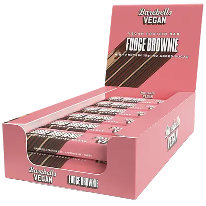 Barebells Vegan Fudge Brownie Proteiinipatukka; vaaleanpunainen suorakulmainen laatikko Barebells Vegan Fudge Brownie -proteiinipatukoita, sisältää useita yksittäin käärittyjä patukoita aseteltuna sisälle; pakkaus on mattapintainen valkoisella ja ruskealla lihavalla groteskitekstillä, jossa sanat kuten ”vegan”, ”protein” ja ”no added sugar”; ei ihmisiä tai käsiä näkyvissä; tausta yksivärinen; tuotekuvassa näkyy vain laatikko ja patukat.