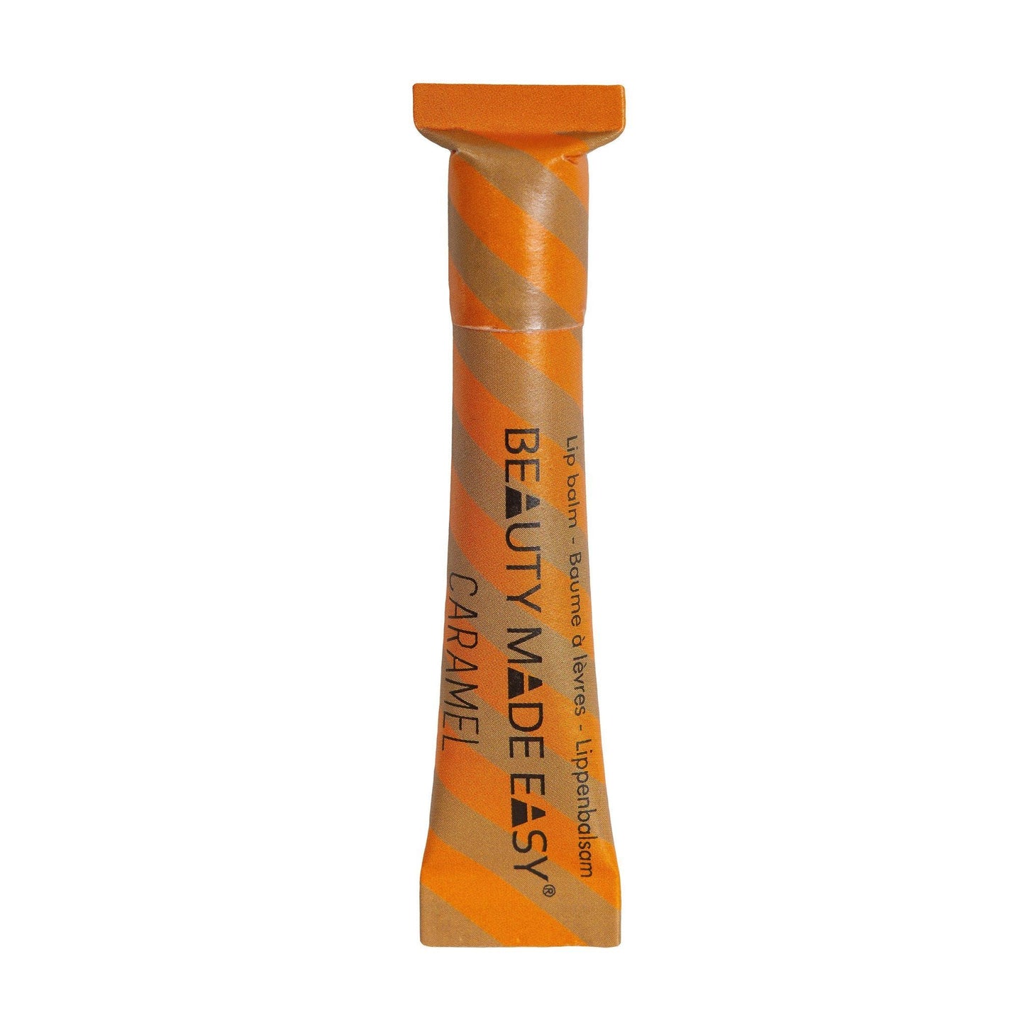 Beauty Made Easy Lip Balm, maku Caramel; tuubi Beauty Made Easy -karamellihuulivoidetta ravitsevin oranssein ja kultaisin viistoraidoin sekä mustalla tekstillä pakkauksessa; tuubi lieriömäinen mattapinnalla; pääetiketissä teksti Beauty Made Easy; valkoinen tausta, ei ihmisiä tai käsiä; lähikuva näyttää vain pakatun huulivoiteen pystyssä.