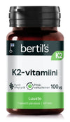 bertils K2-vitamiini -pullo, Suomen lippu, merkitty luuston terveydelle, sisältää 100 µg per tabletti ja 60 tablettia, vihreä ja valkoinen pakkaus korostaen tukea vahvalle luustolle; muovipullo sylinterimäinen kiiltävällä vihreällä kierrekorkilla; etiketti pääosin mattavalkoinen lihavoidulla tekstausvapaalla vihreällä tekstillä ja pienemmällä mustalla painatuksella; tuote yksinkertaisella pinnalla, ei näkyviä ihmisiä tai esineitä.