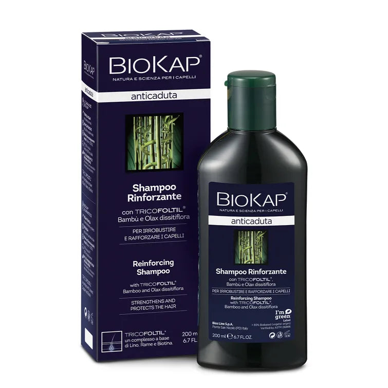 Biokap Anticaduta Shampoo; pullo ja rasia Biokap Anticaduta Shampoo -tuotetta TRICOFOLTIL-ainesosalla, rikastettu bambuuutteella hiusten vahvistamiseksi ja suojaamiseksi; pakkaus tummanruskea vihrein ja valkoisin tikkukirjasintekstein, kiiltäväpintainen, suorakaiteen muotoinen rasia, lieriömäinen pullo läppäkorkilla, molemmissa kuva bambusta; valkoinen tausta, ei ihmisiä tai käsiä näkyvissä.