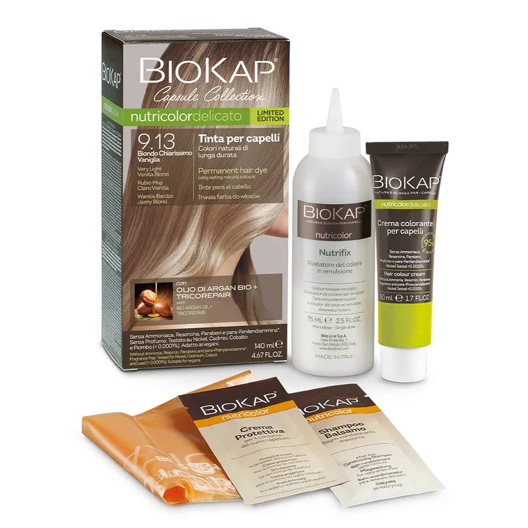 Biokap Nutricolor Delicato Kestoväri; Biokap Nutricolor Delicato -hiusvärisetti sävyssä 9.13 sisältää ravitsevan väriaineen, kehitysaineen, ohjeet, käsineet ja kaksi näytepussia valkoisella taustalla; rasia suorakulmainen pääosin ruskean ja vihreän sävyinen mattapinnalla; luettavissa ”Nutricolor Delicato” ja ”9.13” selkeällä groteskikirjasimella; setin osat tuubeja ja pusseja muovia tai foliota yhteneväisellä etiketöinnillä; kaikki osat aseteltu vierekkäin, ei ihmisiä tai käsiä.